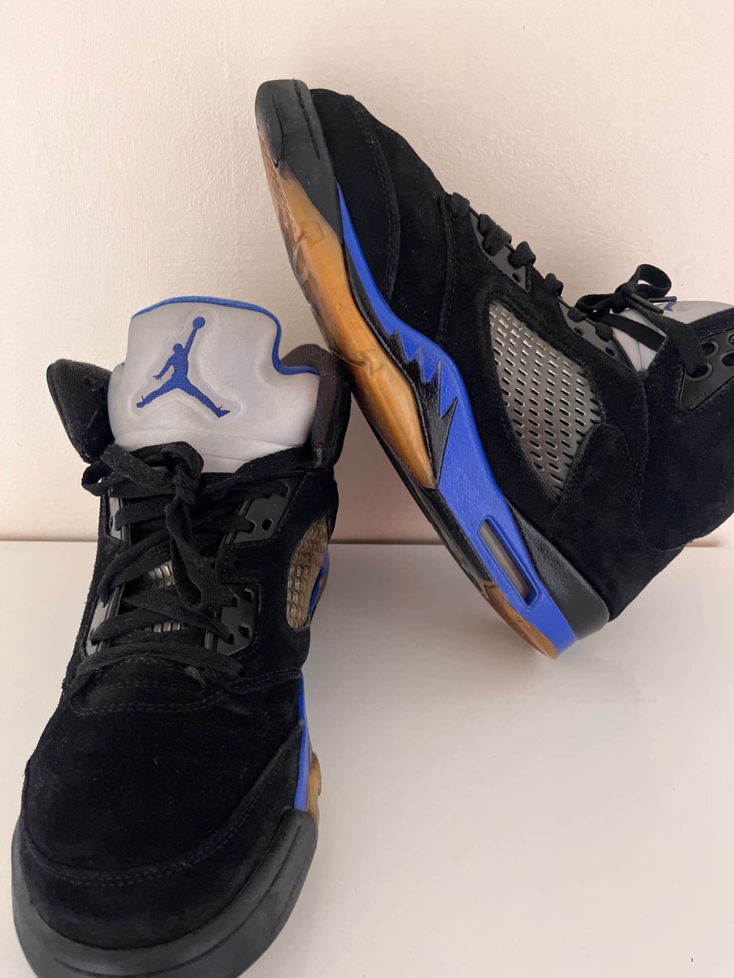 Freshly cleaned black suede Air Jordan 5 sneakers with blue midsole