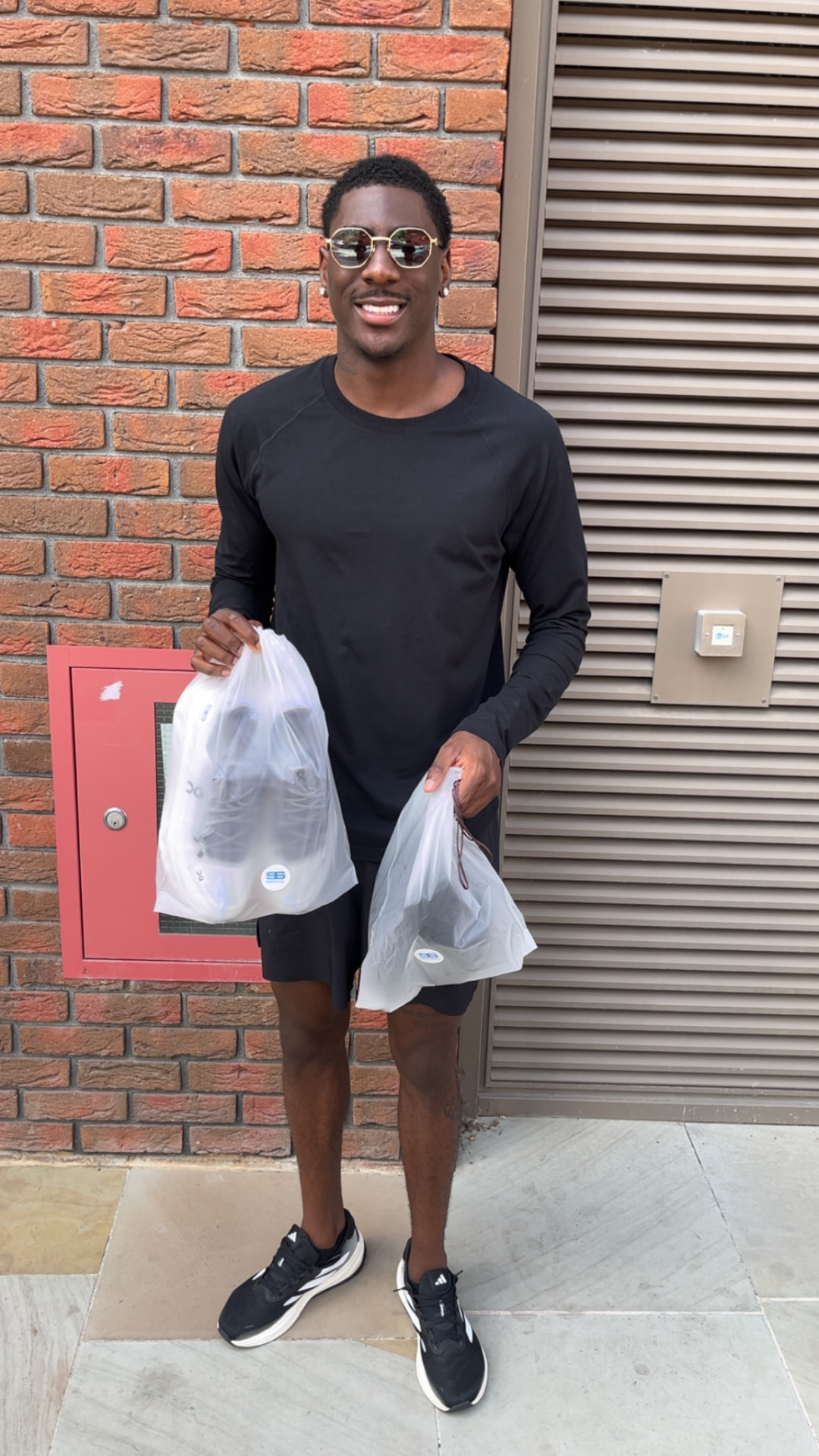 Client collecting cleaned sneakers in Spotless Sneaks bags