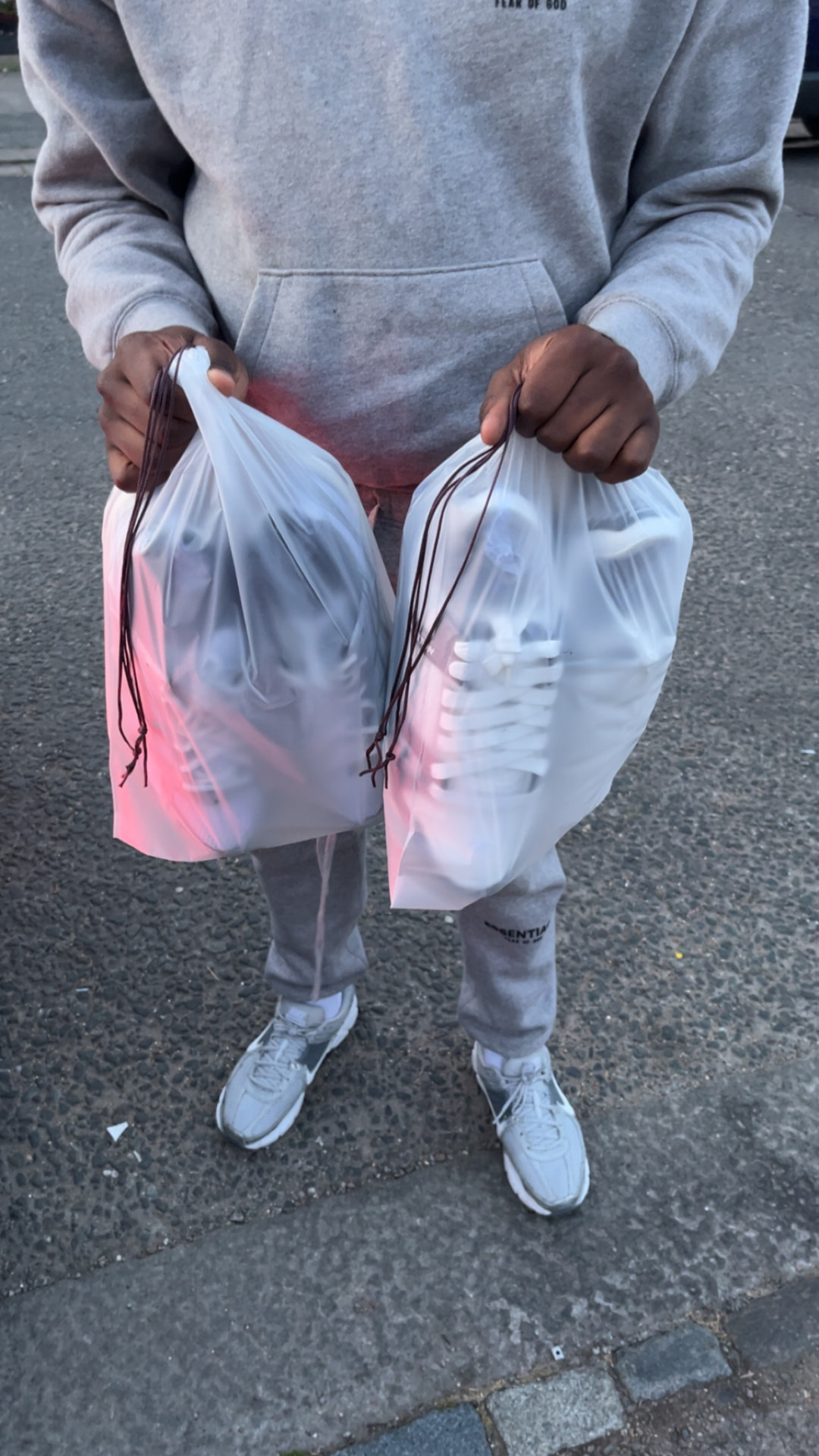 Handover of two bags of cleaned white sneakers to a client